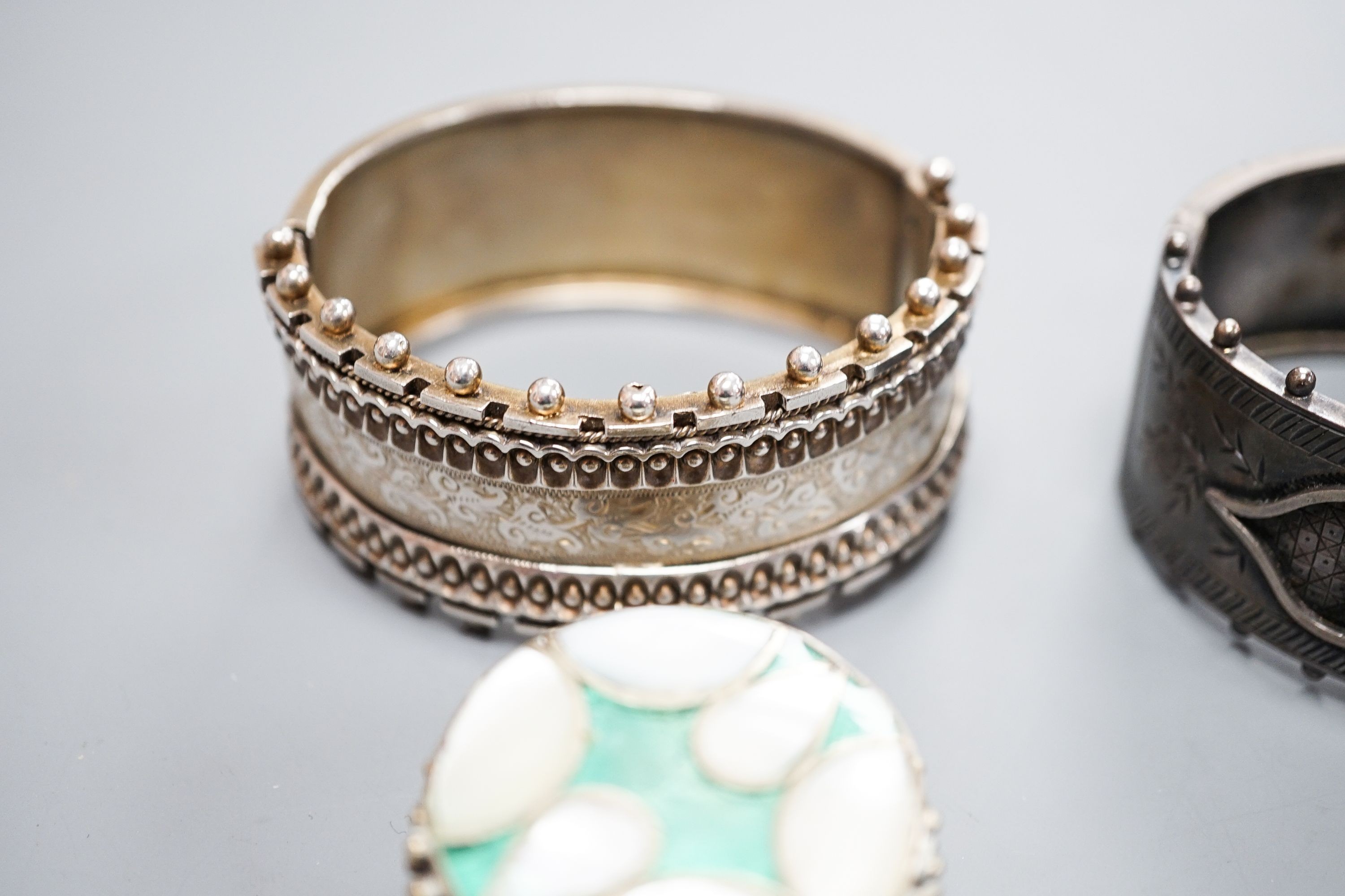 Two white metal bangles including sterling, a marcasite brooch, gem set yellow metal ring and other minor items.